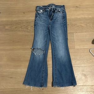 Flared jeans. Darcy blue wash. One ripped knee. Short. Stretch.